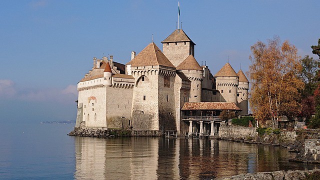 The medieval castle Chateau Chillon stands with a reflection in the water